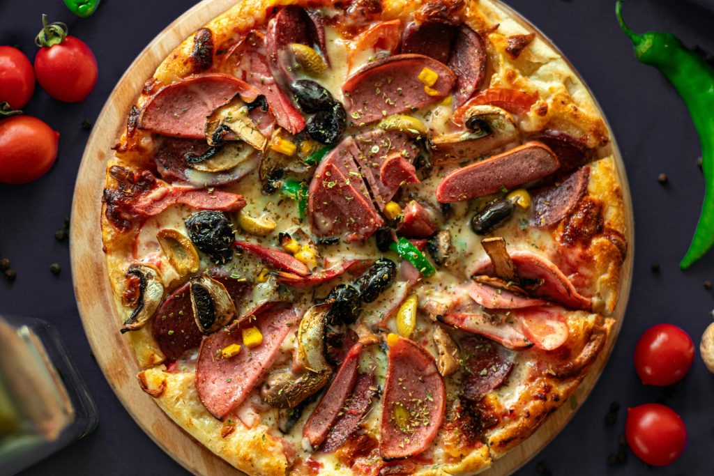 Top view of a freshly baked pizza with meat and vegetables, perfect for food photography lovers.
