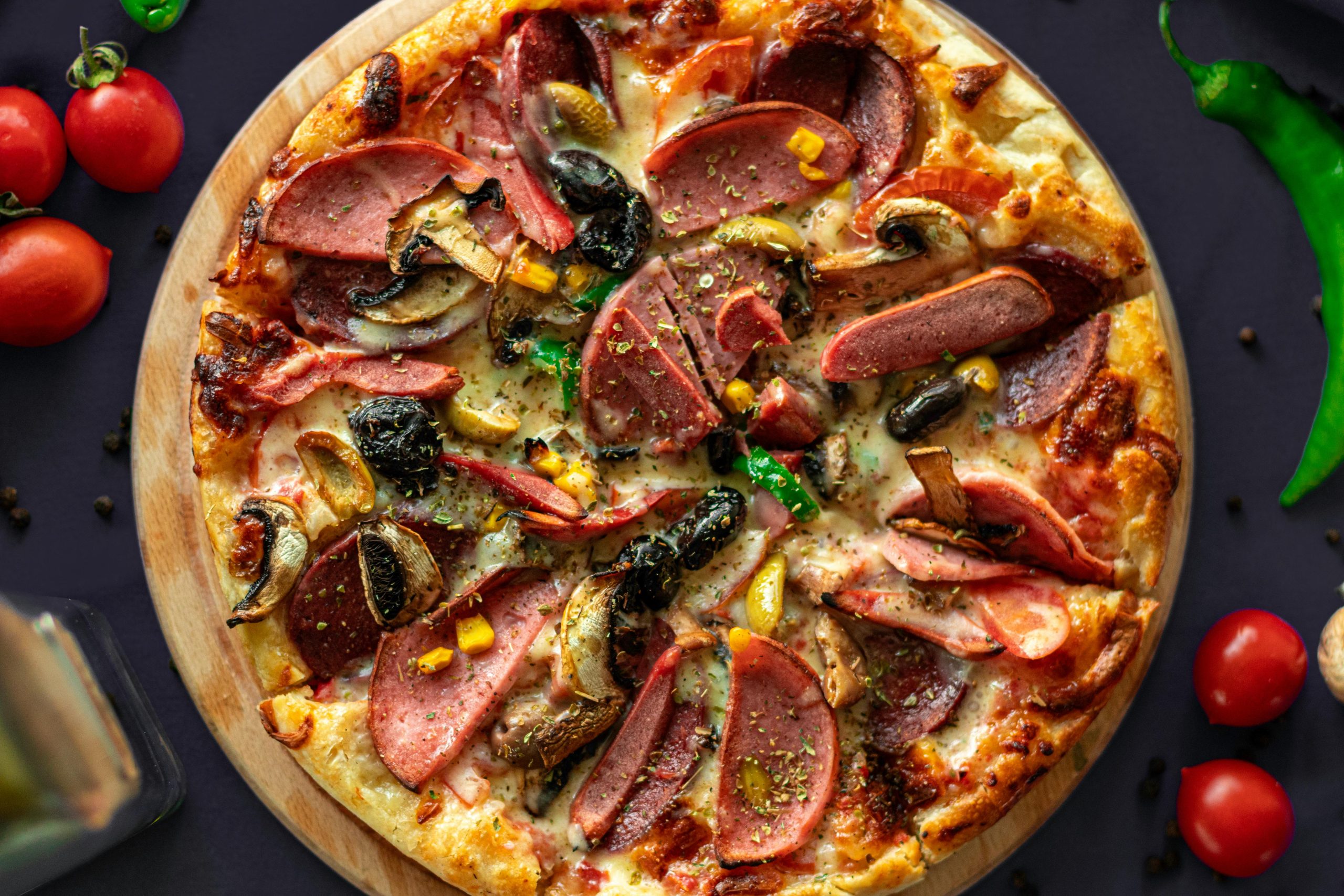 Top view of a freshly baked pizza with meat and vegetables, perfect for food photography lovers.